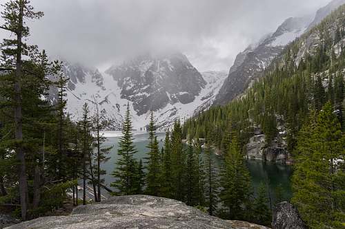 mountain range gray rock mountain leading to river and coated snow mountain nature